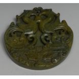A Chinese green hardstone tablet, carved with phoenixes, 8cm diam