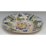 A North European tin-glazed earthenware dish, painted with a bird, leaves, flowers and motifs in