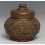 A Tibetan or Nepalese copper ovoid jar and cover, repousse chased with demons and scrolling leaves