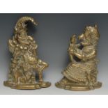 A pair of novelty brass figural door stops, as Punch and Judy, each seated and in grotesque profile,