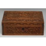 An Indian sandalwood rectangular box, carved with a deity, birds and dense scrolling foliage, hinged