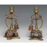 A pair of Arts and Crafts brass and copper candlesticks, in the manner of W.A.S. Benson, each with