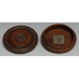 A George III oak circular snuff box, the draught turned cover enclosing an apocryphal interior as