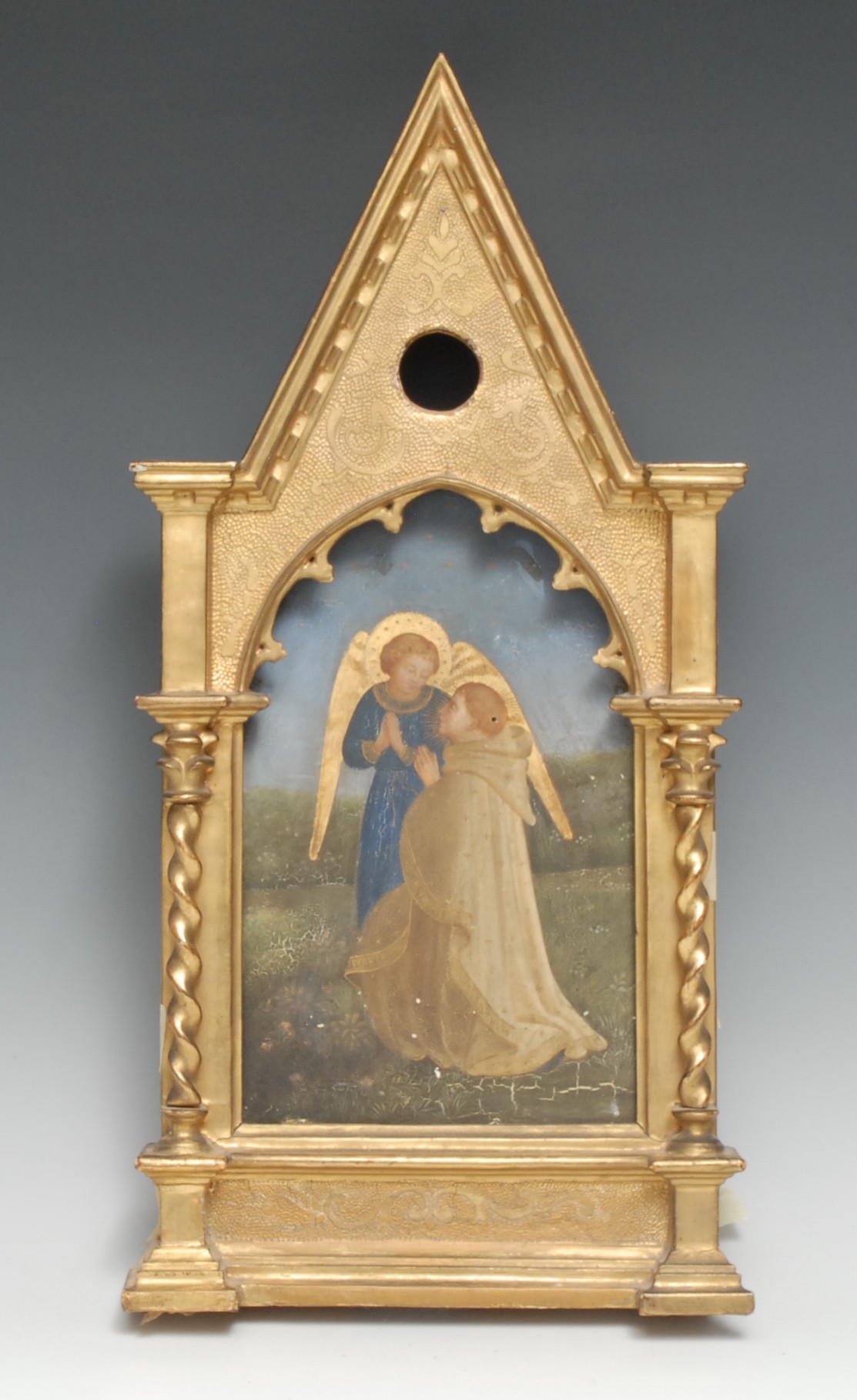 A 19th century Gothic Revival giltwood and gesso devotional icon, the arched panel painted with an