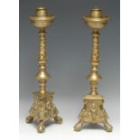 A pair of North European Baroque gilt brass candlesticks, dished drip pans, spiral knopped