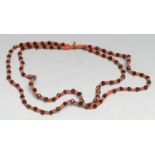 A two-strand necklace, formed of jet and coral beads, 23cm drop