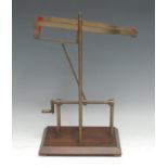 A brass and mahogany mechanical wine pouring cradle, screw-thread mechanism with cranking handle,