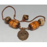 Tribal Art - an African necklace, composed of bone barrel shaped beads and a bronze 'passport' mask,