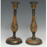 A pair of Kashmiri candlesticks, decorated in polychrome and gilt with scrolling stylised flowers