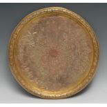 An Ottoman gilt copper circular tray, densely chased with foliage and scrolling leafy tendrils, 34cm