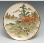 A Japanese Satsuma circular plate, typically in polychrome and gilt with a watermill at the foot