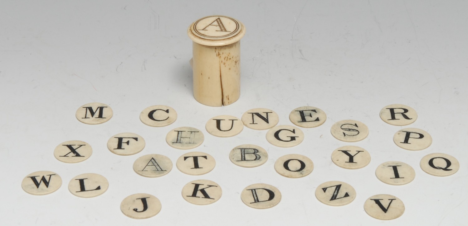 A 19th century bone child's teaching spelling alphabet, the circular counters contained within a