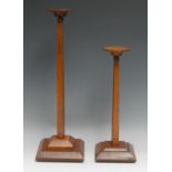 Millinery - a graduated pair of early 20th century oak adjustable shop display hat stands,