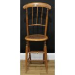 A Victorian beech child's correction chair, curved cresting rail, turned spindle back, oval cane