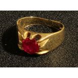 A 14k gold ring set with a single faceted ruby, 6.4g