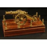 A brass and mahogany model desk cannon, 23cm across the base