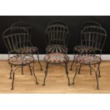 A set of six wrought iron garden or cafe chairs, each with a spoon-shaped slatted back, circular