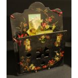 A 19th century papier mache wall mounted letter rack, decorated with tyrolian scenes and blossom,