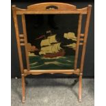 A 1930s Arts and Crafts oak firescreen, central glazed panel of a sailing ship, 101cm high, 63cm