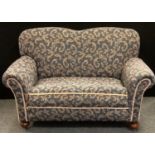 A Victorian drop arm two seater sofa, scrolling floral upholstery, 91cm high, 157cm long.