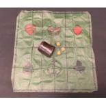 A game of Crown & Anchors with cloth 'board', dice and cup