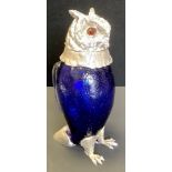 A contemporary silver plated and blue glass novelty decanter, in he form of an owl, glass eyes, 29cm