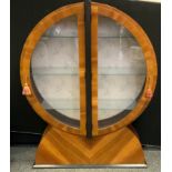 A Superlative Art Deco display cabinet of circular form, butterfly glazed doors enclosing glass