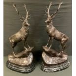 After Jules Moigniez, a pair of bronzed metal stags, modelled on a naturalistic rocky outcrop,
