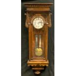 A Victorian oak carved Vienna wall clock, eight day movement, cream enamel dial, bold Roman