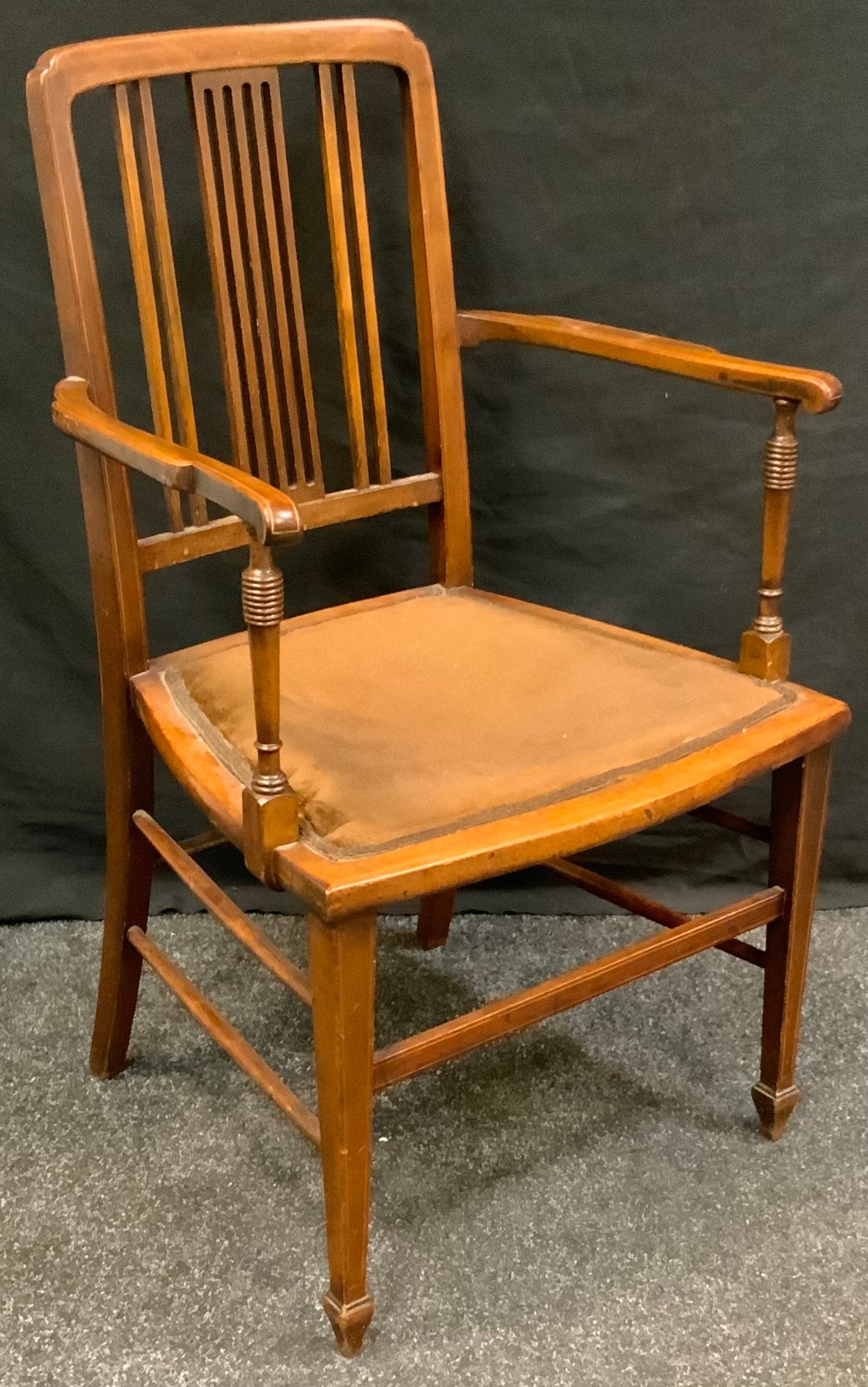 An Edwardian mahogany open arm chair, outlined throughout with ebony and boxwood stringing,