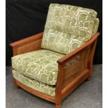 An Ercol golden oak bergere armchair, green and cream cushioned back and seat