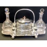 A contemporary silver plated decanter set, with two clear glass decanters, central wafer box, and