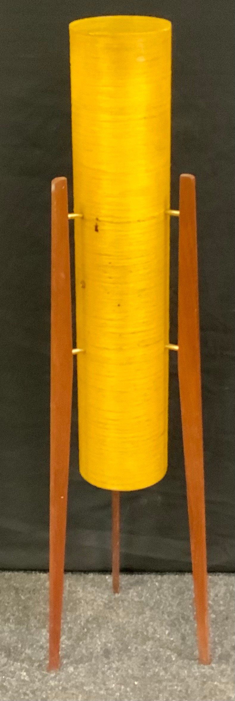 A retro floor standing Rocket lamp, amber conical shade, on three teak stands