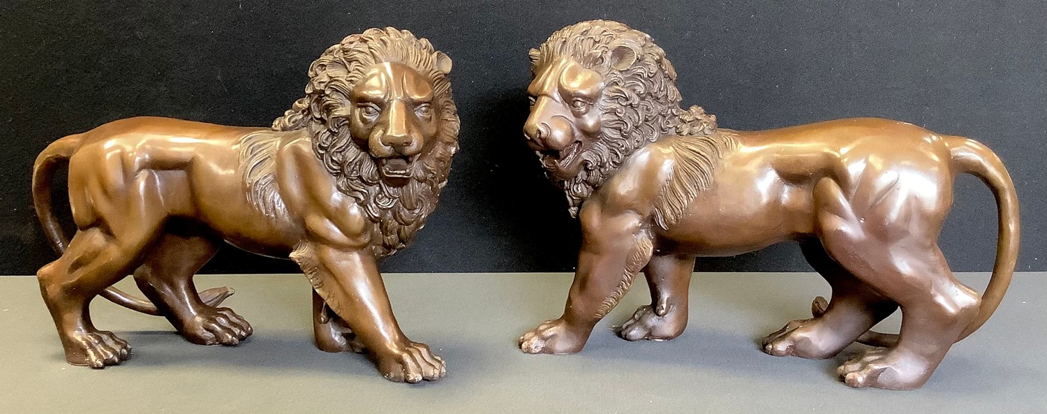 Contemporary School, a pair of brown patinated bronzes, Lions, standing, 32cm wide