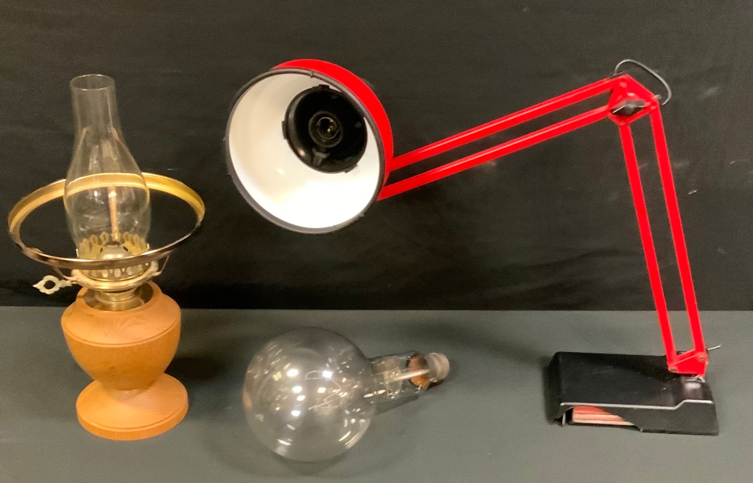 A red angle poise lamp; Chris Withers turned oak oil lamp, vintage giant screw thread bulb.