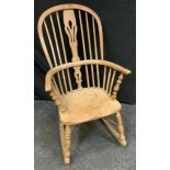 A late 19th century bentwood spindle back rocking chair, pierced central splat, shaped seat,