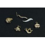 A 14k gold trolley car charm, a 9ct gold elephant charm, a 9ct gold horn charm, another charm,