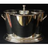 A contemporary silver plated ice bucket, for two bottles, with central ice container, stepped oval