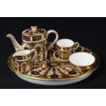 A Royal Crown Derby Imari 1128 pattern miniature tea set on an oval tray, comprising teapot, milk