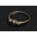 A 10k gold ring set with a central sapphire flanked by two faceted clear stones, ring size M, 1.5g
