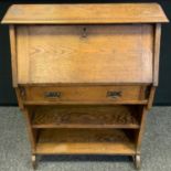 An Arts & Crafts oak student's bureau, fall front enclosing pigeonholes, above a drawer and a