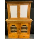 A country house pine dresser top, outswept cornice above a pair of domed glazed doors enclosing