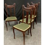 A set of four Art Nouveau dining chairs shaped and pierced top rail, pierced splats, padded seat,