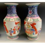 A pair of contemporary Chinese porcelain vases, decorated with traditional figures in the famille