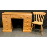 A contemporary pine desk, rectangular top above a central long drawer flanked by four short drawers,