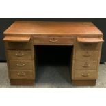 A 20th century oak kneehole desk, flush rectangular top, short central drawer flanked by sliding