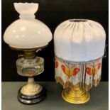 A Victorian oil lamp, clear glass reservoir, 42cm high, c.1870; another; a lamp, beaded fringe