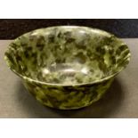 A polished green stone circular bowl, possibly Nephrite Jade, 10cm diameter.