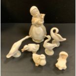 A Lladro goose, printed mark; others; a Nao figure of a girl, with a lamb; etc