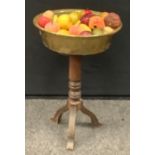 Faux fruit in a brass bowl, on associated torchere stand